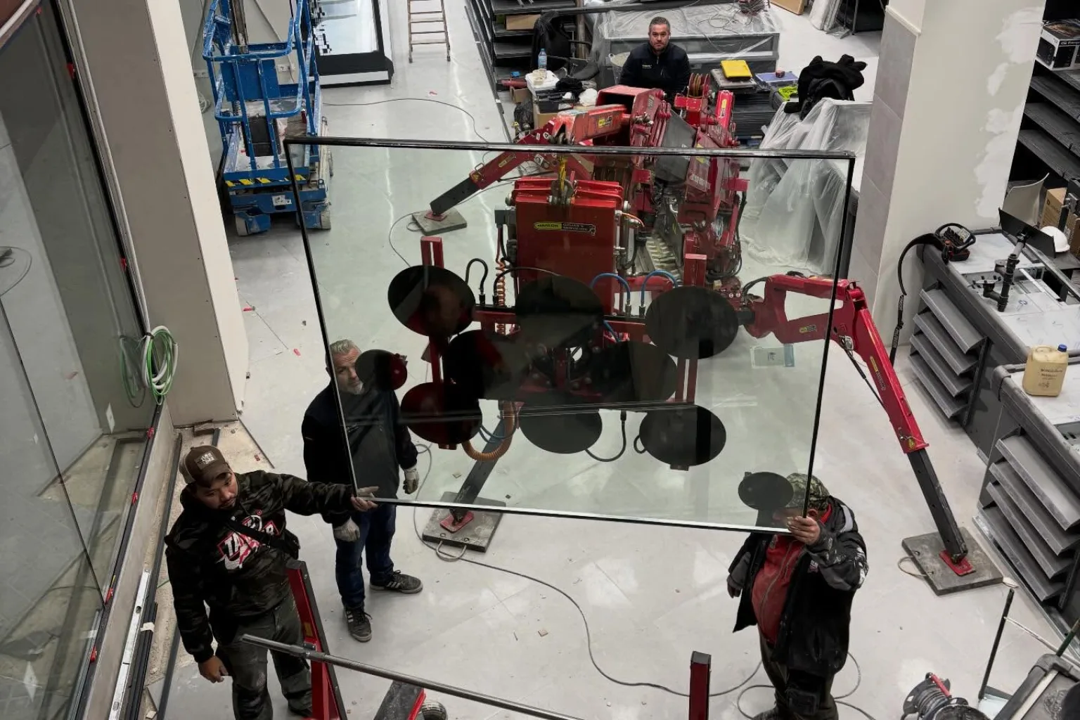 Equipo de RM Cristalería montando doble acristalamiento con mini grúa en un supermercado